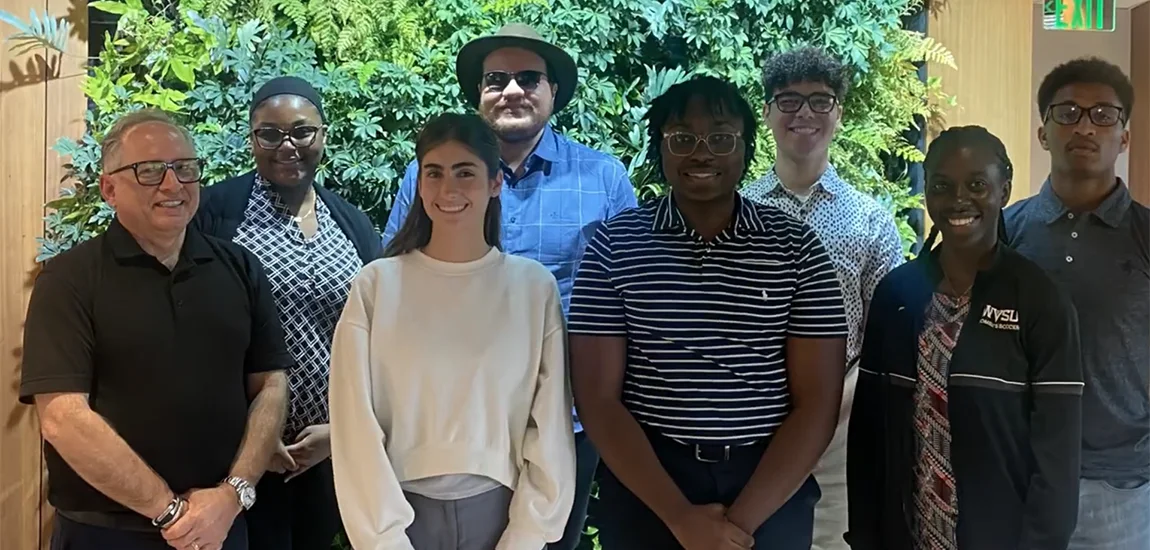 Group of people standing and smiling at the camera